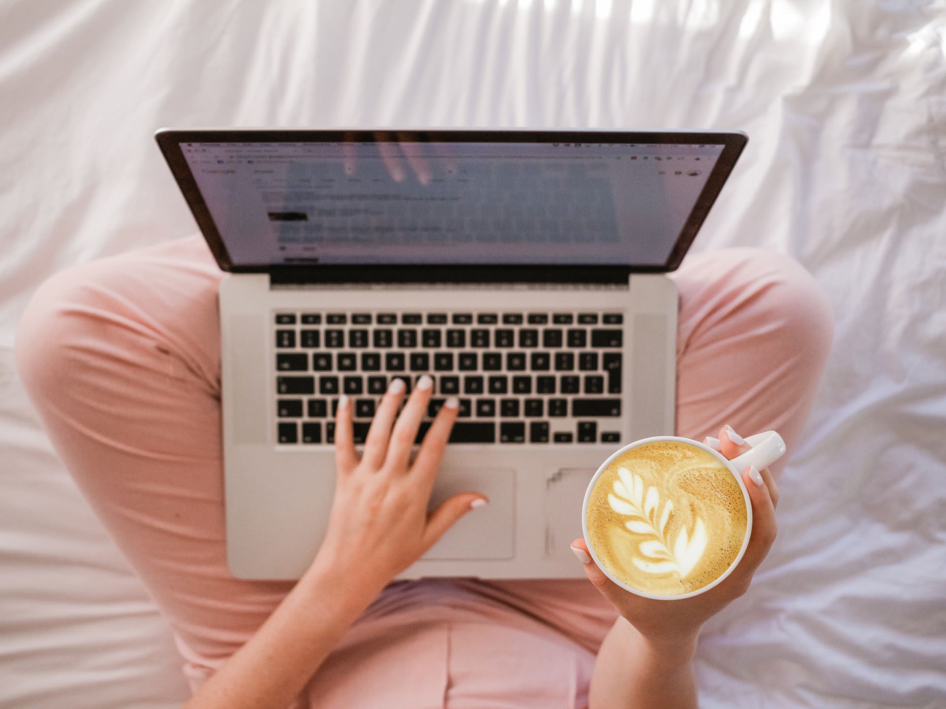 Can a Blog Be About Anything? Person sitting on bed with laptop and coffee.